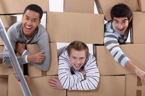 Boxes and furniture arranged for a cubic-yard estimate in a Hackney property