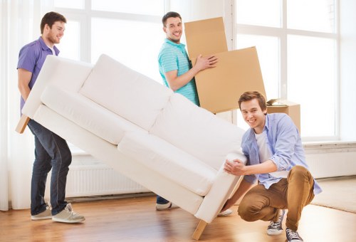 Movers carrying household items through a Hackney property staircase